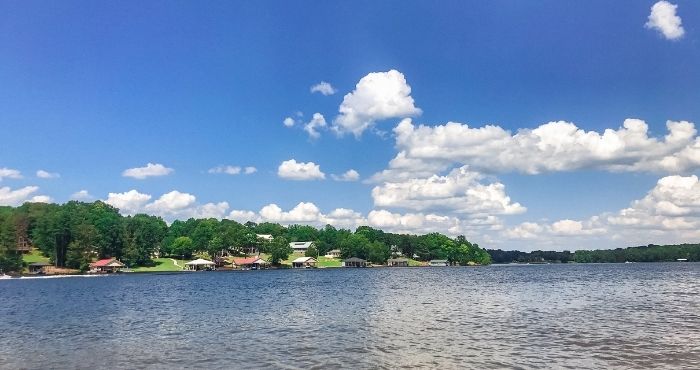 Houses on the lake surrounded by green trees